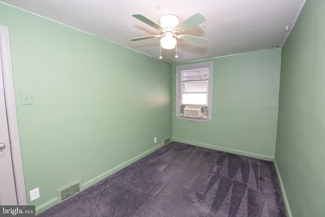 empty room featuring ceiling fan, baseboards, visible vents, and dark carpet