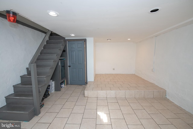 finished below grade area featuring recessed lighting, stairway, and tile patterned floors