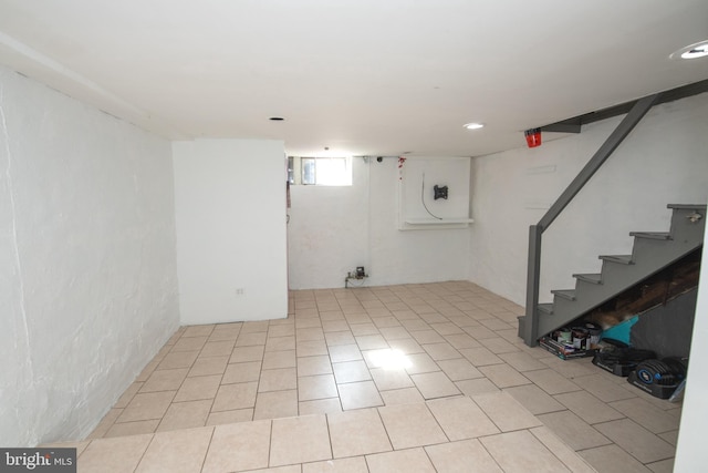 basement with tile patterned flooring and stairway