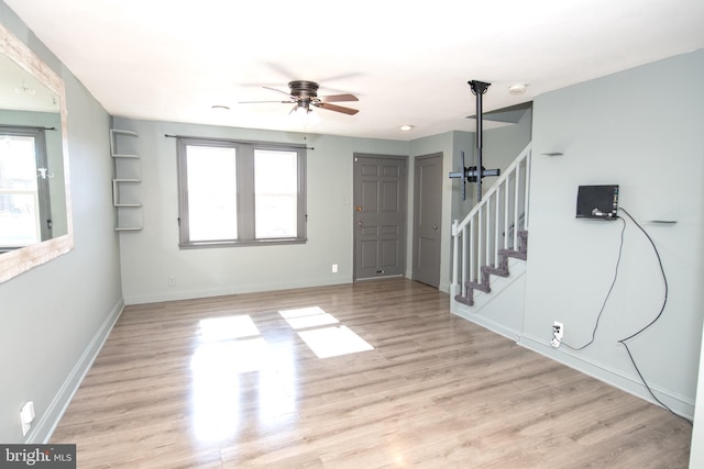 interior space featuring plenty of natural light, light wood-style flooring, baseboards, and stairs