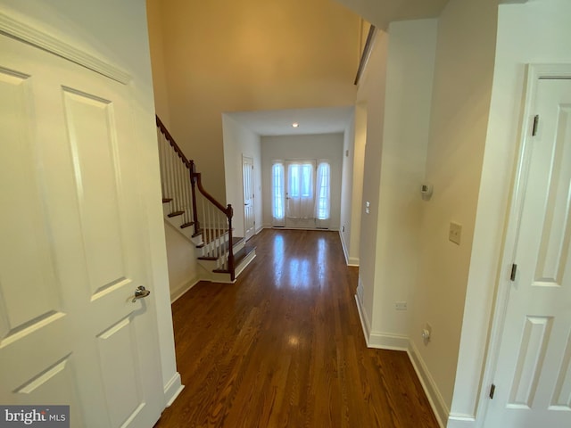 entryway with baseboards, dark wood-style floors, and stairs