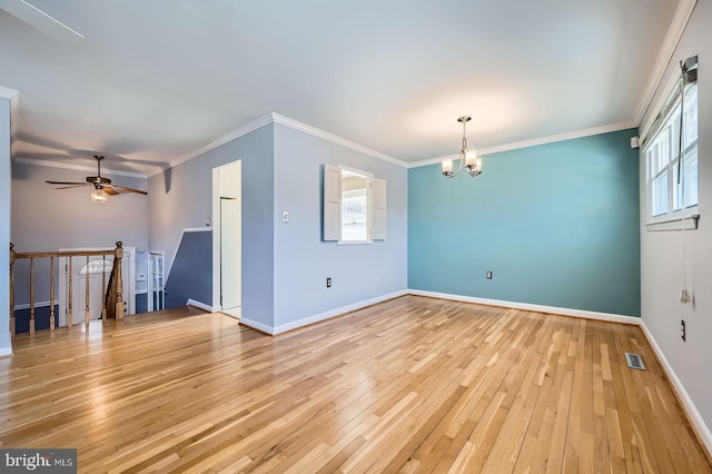 empty room featuring visible vents, baseboards, light wood-style floors, and ornamental molding