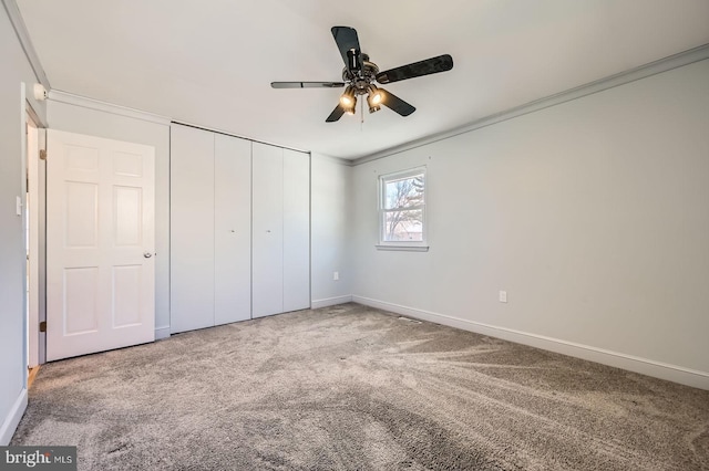 unfurnished bedroom with a closet, carpet floors, and baseboards