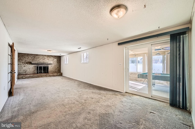 unfurnished living room featuring a textured ceiling, a fireplace, and carpet flooring