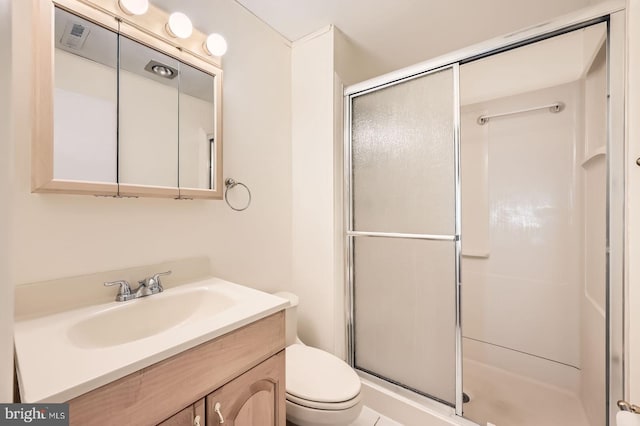 bathroom featuring vanity, a shower stall, toilet, and visible vents