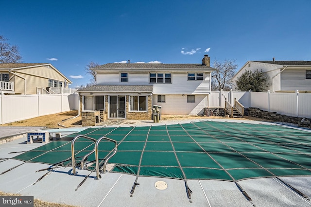 view of swimming pool featuring a patio area, a fenced in pool, a fenced backyard, and a sunroom