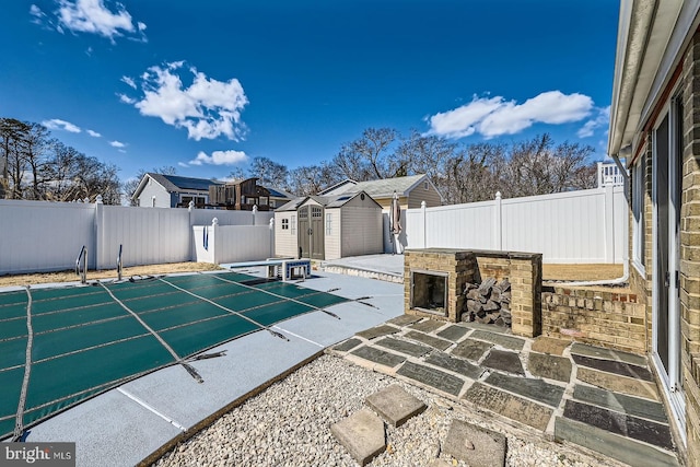 view of patio / terrace with a storage unit, an outbuilding, and a fenced backyard