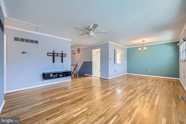 unfurnished living room with visible vents, ornamental molding, attic access, and wood-type flooring