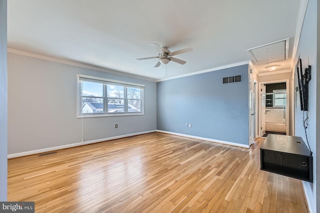 empty room featuring visible vents, baseboards, attic access, and light wood finished floors