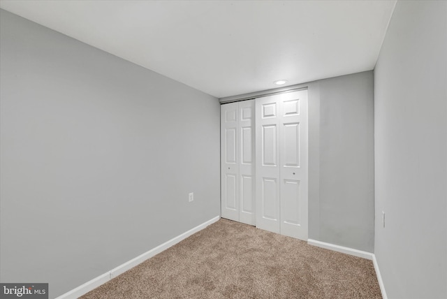 unfurnished bedroom featuring carpet flooring, baseboards, and a closet