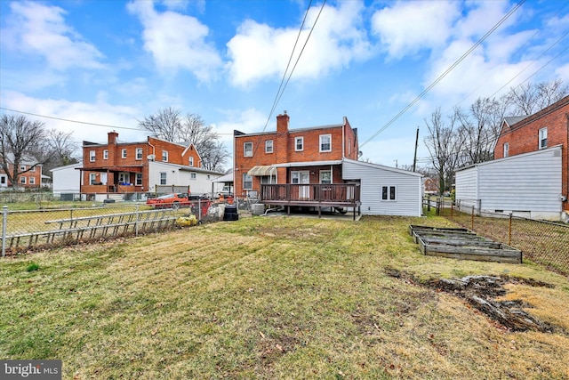 back of house featuring a yard, a fenced backyard, and a vegetable garden