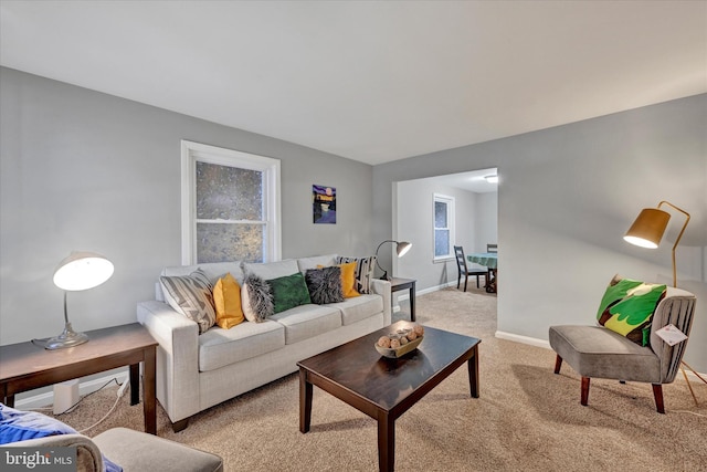 living room with baseboards and light colored carpet