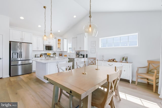 dining room featuring recessed lighting, light wood-style floors, and high vaulted ceiling