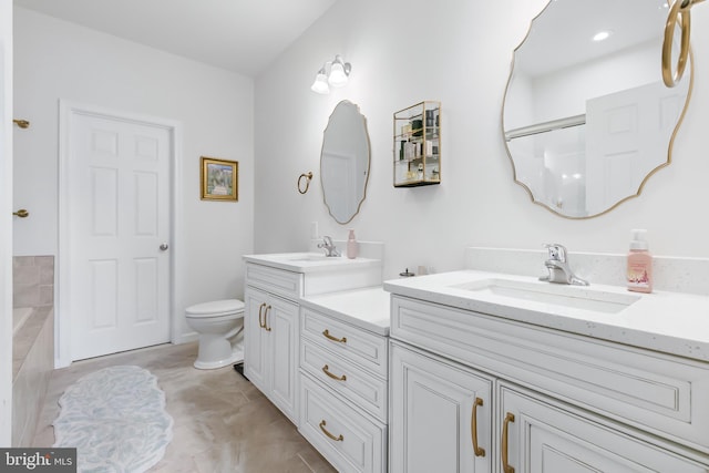 full bath featuring a sink, toilet, a bath, and double vanity