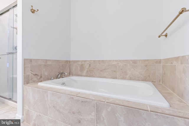 full bathroom featuring a bath and a shower stall