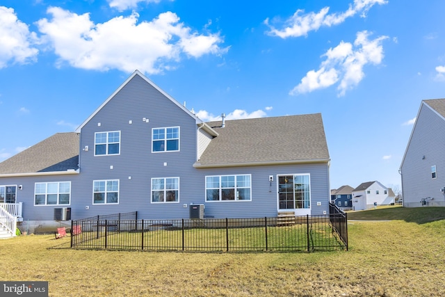 back of property with a yard, central air condition unit, roof with shingles, and fence