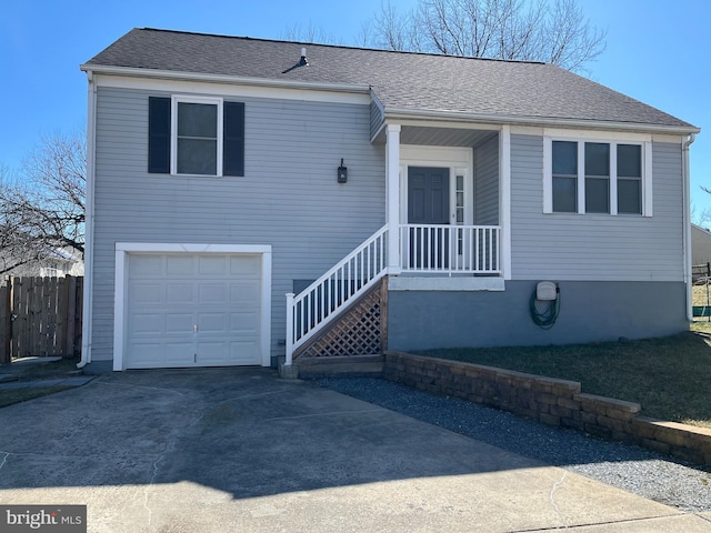 view of front of house featuring concrete driveway, an attached garage, fence, and a shingled roof