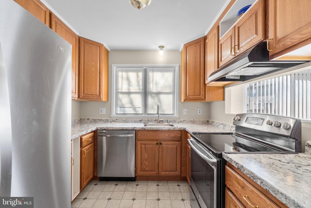 kitchen featuring a sink, stainless steel appliances, under cabinet range hood, and brown cabinetry