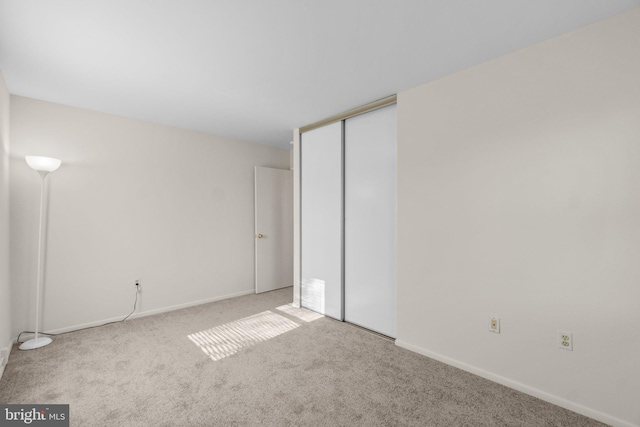 unfurnished bedroom with a closet, baseboards, and carpet