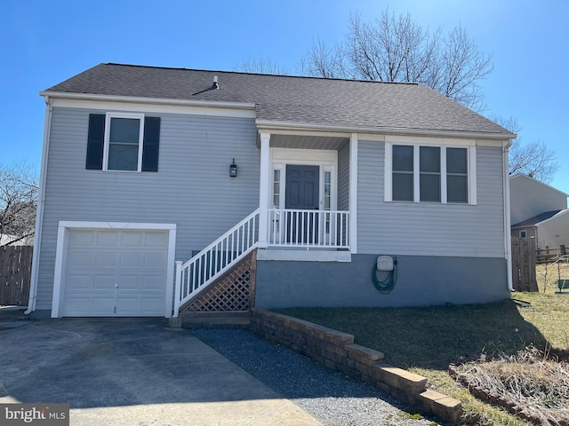 view of front of property featuring a shingled roof, an attached garage, concrete driveway, and fence