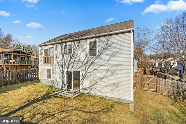 rear view of property with a lawn and fence