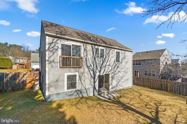 rear view of property featuring a fenced backyard, central air condition unit, and a yard