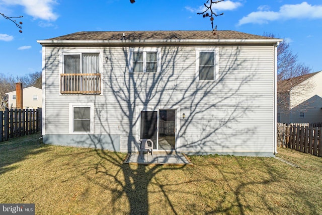 back of house featuring a yard, a fenced backyard, and a patio area