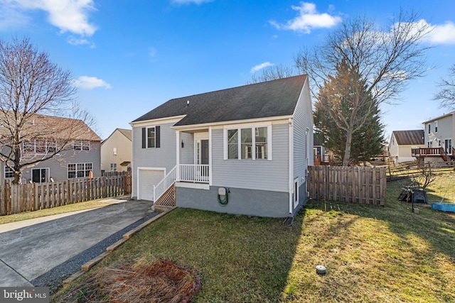 view of front of property featuring a front yard, an attached garage, driveway, and fence