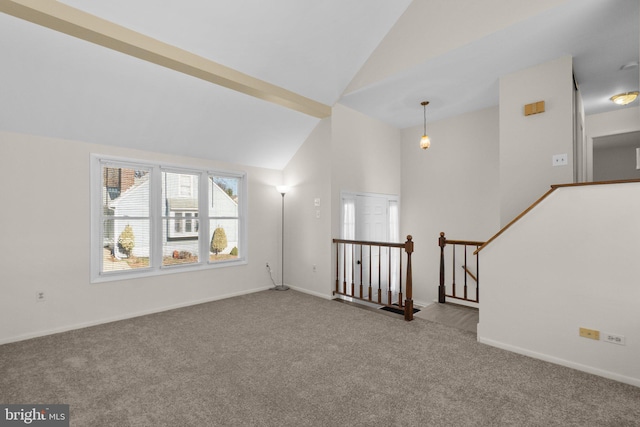 unfurnished living room with carpet flooring, high vaulted ceiling, and baseboards