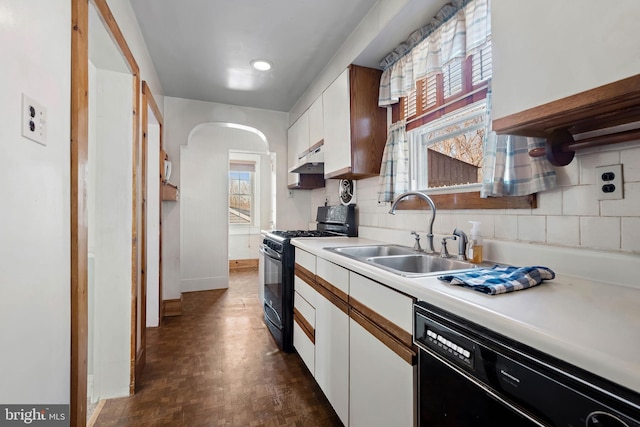 kitchen with a sink, black appliances, white cabinets, light countertops, and under cabinet range hood