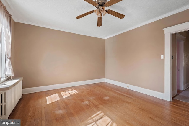 empty room with baseboards, ceiling fan, ornamental molding, a textured ceiling, and light wood-type flooring