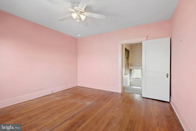 empty room with hardwood / wood-style flooring, baseboards, and ceiling fan