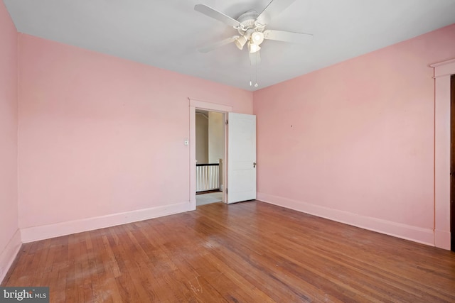 spare room featuring ceiling fan, baseboards, and hardwood / wood-style floors