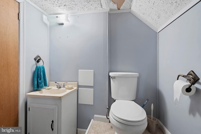 bathroom with vanity, toilet, and baseboards