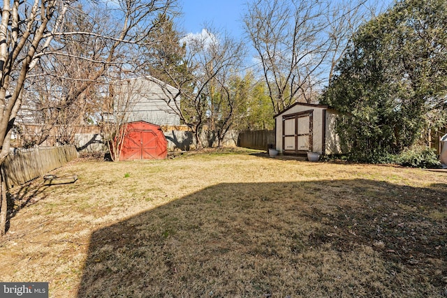 view of yard with a storage unit, an outdoor structure, and a fenced backyard