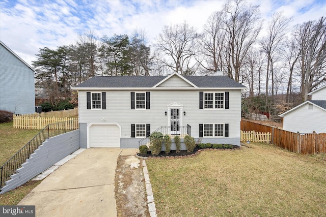 bi-level home with a garage, a front yard, fence, and driveway