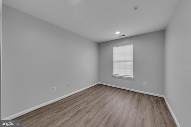 unfurnished room with visible vents, baseboards, and wood finished floors