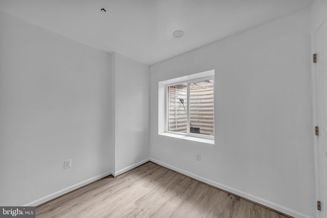 spare room featuring wood finished floors and baseboards