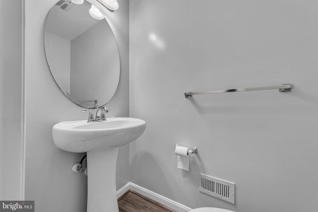 bathroom featuring visible vents, baseboards, and wood finished floors