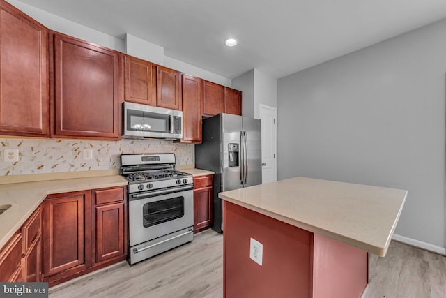 kitchen with stainless steel appliances, light wood finished floors, and light countertops