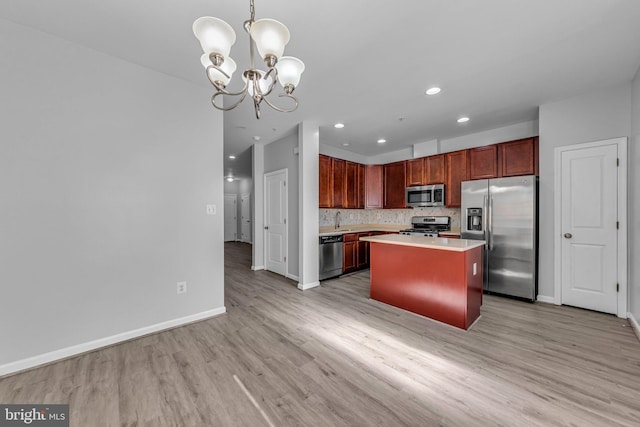 kitchen featuring baseboards, stainless steel appliances, light countertops, light wood-style floors, and backsplash