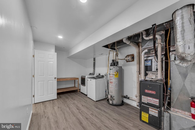 interior space with gas water heater, laundry area, wood finished floors, baseboards, and washing machine and clothes dryer