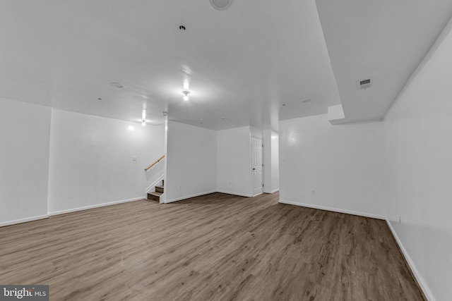 interior space featuring baseboards, stairway, and wood finished floors