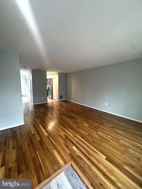 unfurnished living room with baseboards and wood finished floors