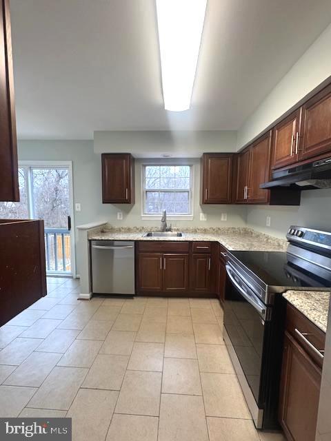 kitchen featuring a wealth of natural light, electric range, a sink, dishwasher, and under cabinet range hood