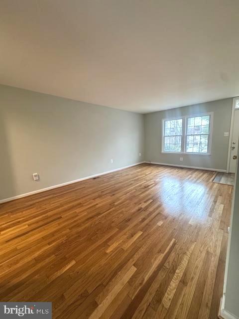 empty room with baseboards and wood finished floors