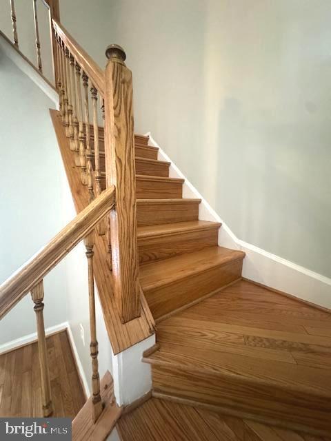 stairway featuring baseboards and wood finished floors