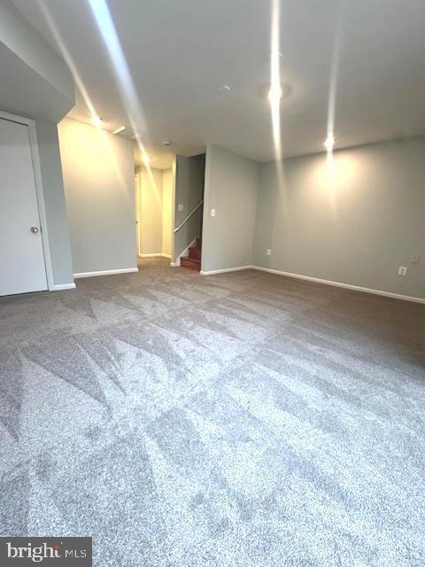 finished below grade area with stairs, carpet floors, and baseboards