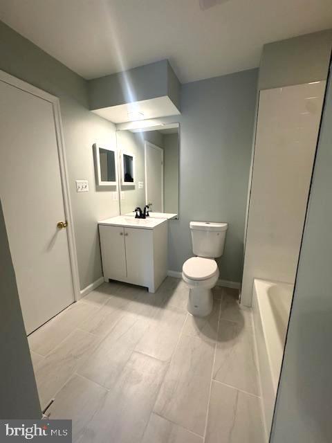 full bathroom featuring toilet, vanity, baseboards, a shower, and a tub