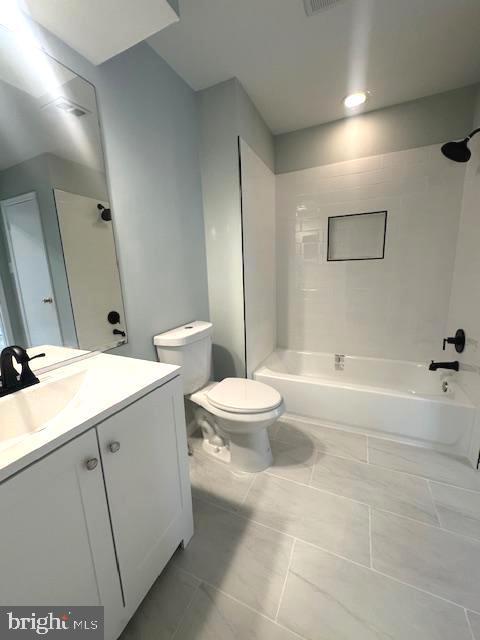 full bath with toilet, vanity, and bathing tub / shower combination